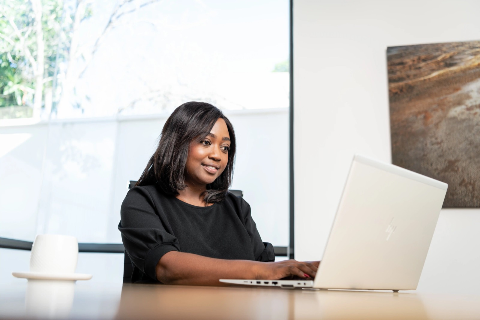 A Potentia colleague working at a laptop in the Windhoek boardroom